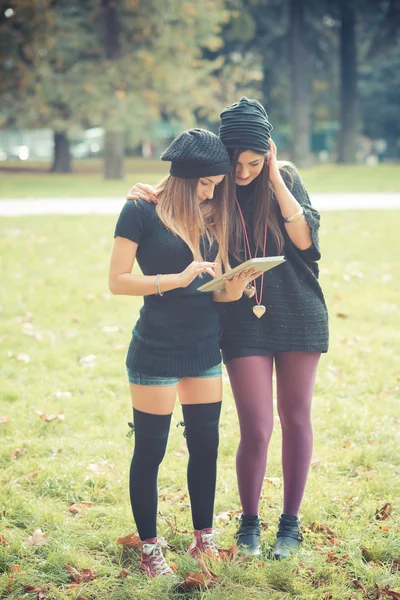 Две девушки с помощью планшета на открытом воздухе — стоковое фото
