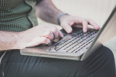 Adamın elleri dizüstü bilgisayar kullanarak