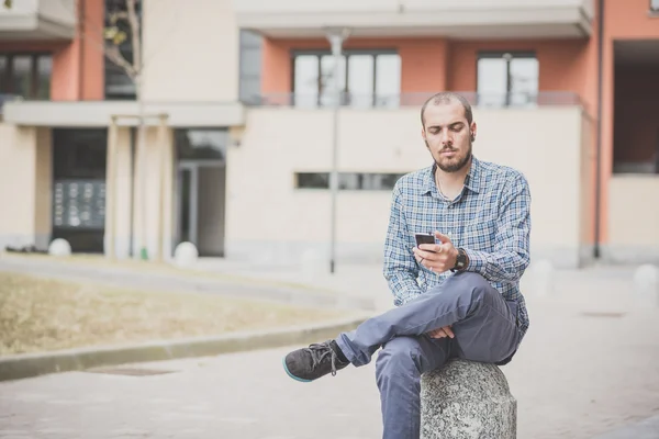 Hombre casual escuchando música y usando smartphone —  Fotos de Stock