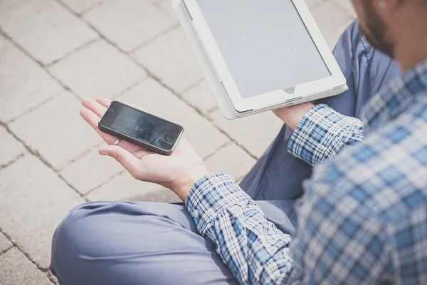 Современный человек держит планшет и мобильный телефон — стоковое фото