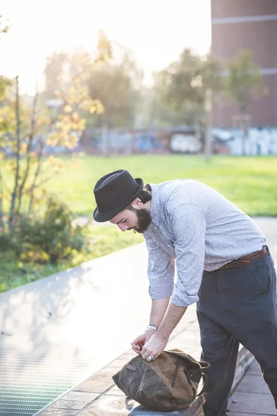 Hipster skäggig man i hatt med väska — Stockfoto