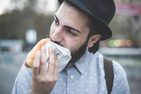 Hipster homem comendo cachorro quente — Fotografia de Stock