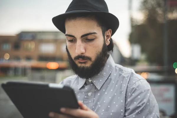 Hipster gay in hat using digital tablet — Stock Photo, Image