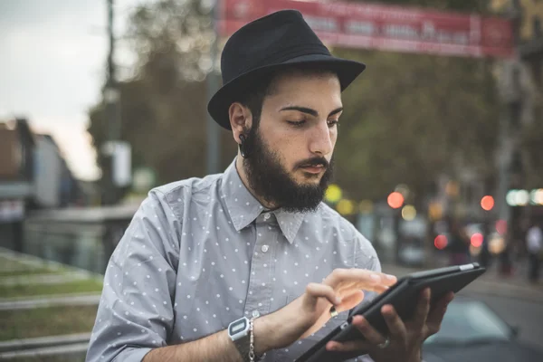 Hipster γκέι στο καπέλο χρησιμοποιώντας ψηφιακή δισκίο — Φωτογραφία Αρχείου