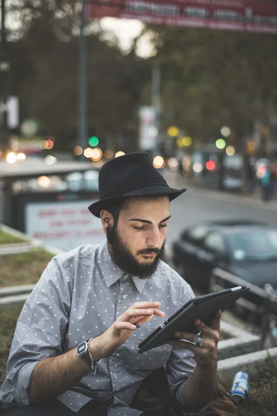 Hipster gay i hatt med digital tablet — Stockfoto
