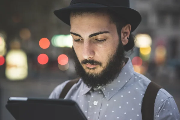 Hipster gay no chapéu usando tablet digital — Fotografia de Stock