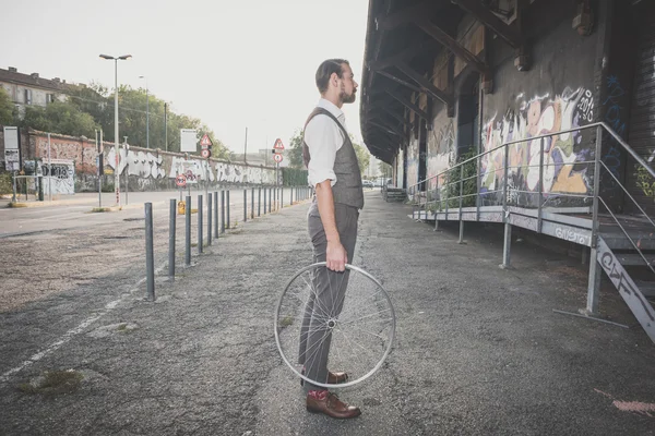 Uomo che tiene vecchia ruota della bicicletta — Foto Stock