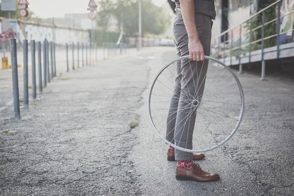 Uomo che tiene vecchia ruota della bicicletta — Foto Stock