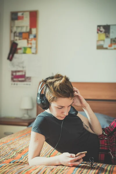 Young lesbian stylish hair style woman listening to music — Stock Photo, Image