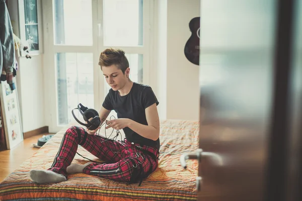 Jonge lesbische stijlvolle haren stijl vrouw luisteren naar muziek — Stockfoto