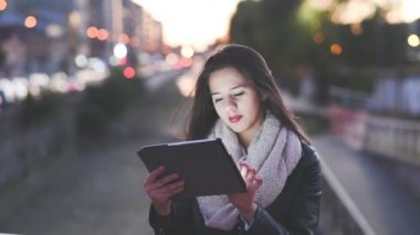 Tablet kullanan genç bir kadın.
