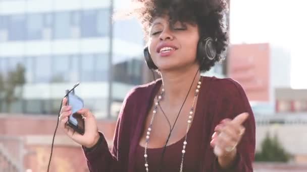Fröhliches afrikanisches Mädchen hört Musik — Stockvideo