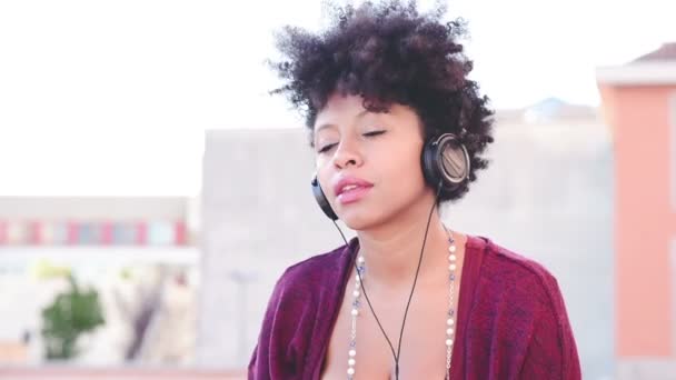 Happy african girl listening music — Stock Video