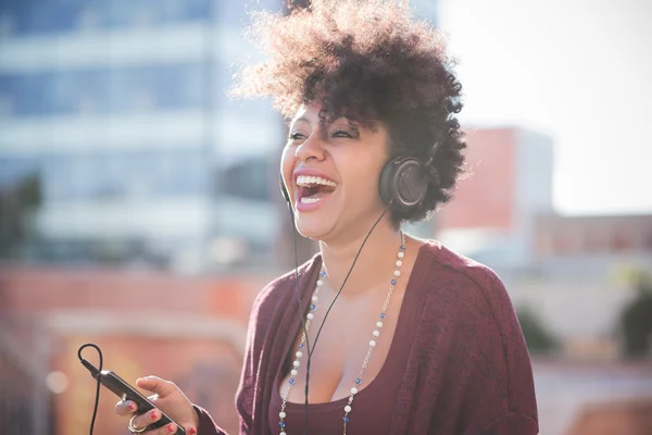 Vacker kvinna lyssnar musik i hörlurar — Stockfoto