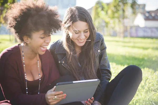 Dos mujeres multiétnicas con tableta — Foto de Stock