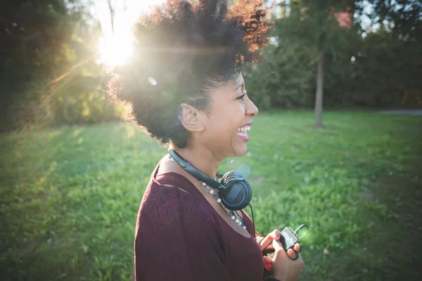 Schöne afrikanische Frau hört Musik — Stockfoto