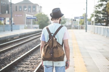 Tren istasyonunda bekleyen hipster adam