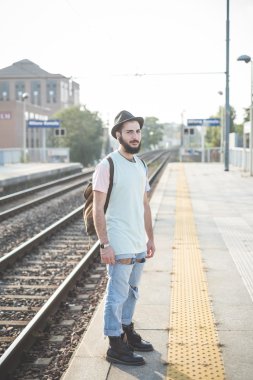 Tren istasyonunda bekleyen hipster adam