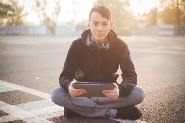 Joven asiático hombre escuchando música — Foto de Stock