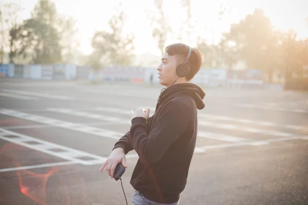 Jovem asiático homem em fones de ouvido — Fotografia de Stock