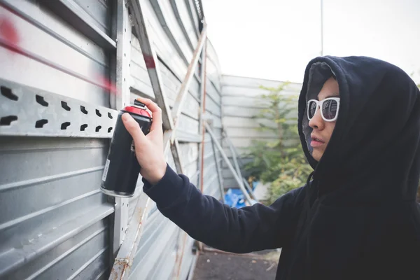 Unga asiatiska hip hop man rita graffiti — Stockfoto