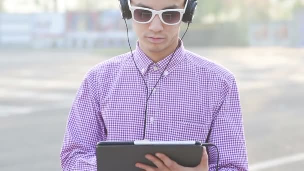 Asiático hombre escuchar música con tablet — Vídeo de stock