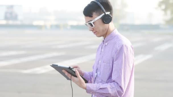 Asiático hombre escuchar música con tablet — Vídeo de stock