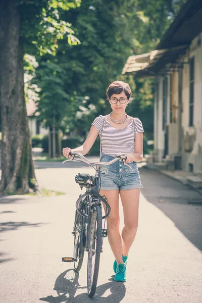 Joven mujer hipster con bicicleta — Foto de Stock