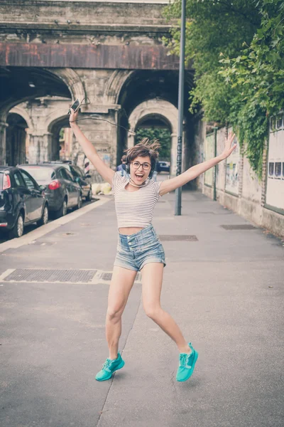 Junge Hipsterfrau hört Musik beim Springen — Stockfoto