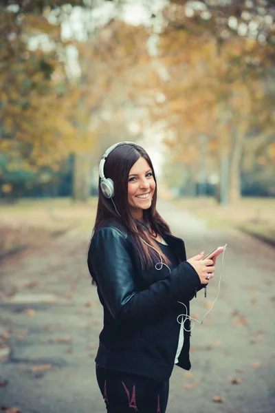 Jeune fille dans le parc écouter de la musique — Photo