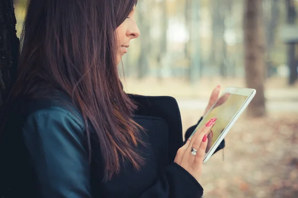 Ung flicka med tablett i park — Stockfoto