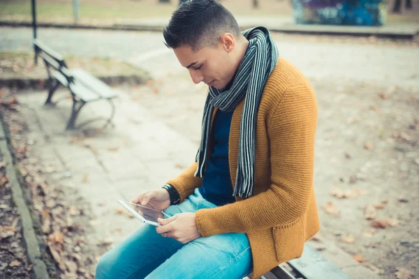 Stilig man i parken med hjälp av Tablet PC — Stockfoto