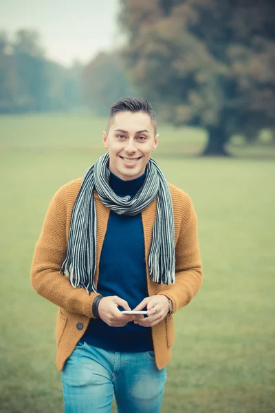 Bărbat în parcul de toamnă cu smartphone — Fotografie, imagine de stoc