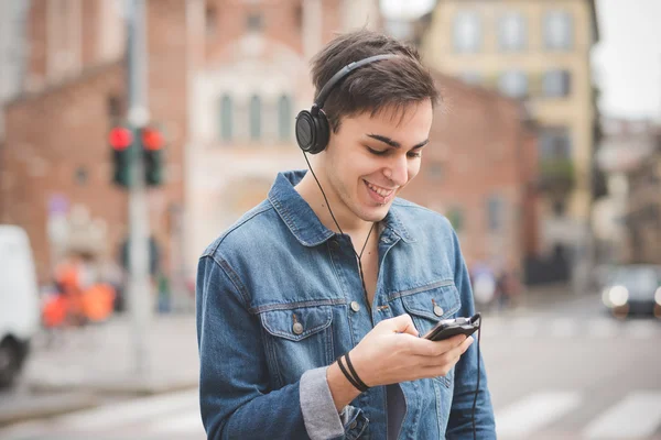 Jongeman met koptelefoon die muziek luistert — Stockfoto