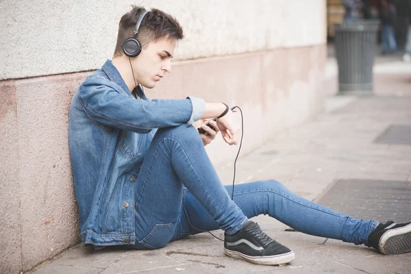 Fiatal férfi fülhallgatóval zenét hallgat — Stock Fotó