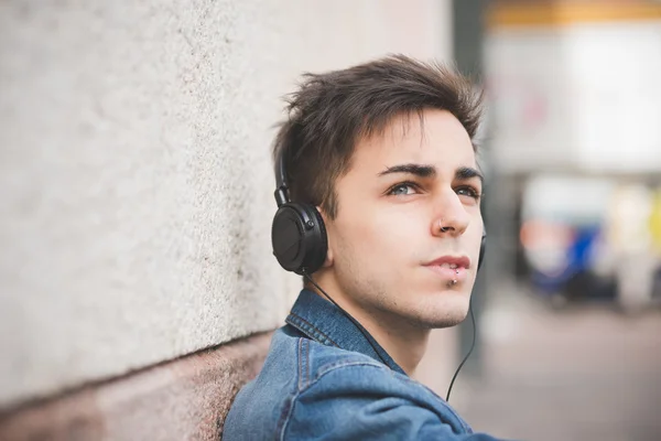 Jongeman met koptelefoon die muziek luistert — Stockfoto