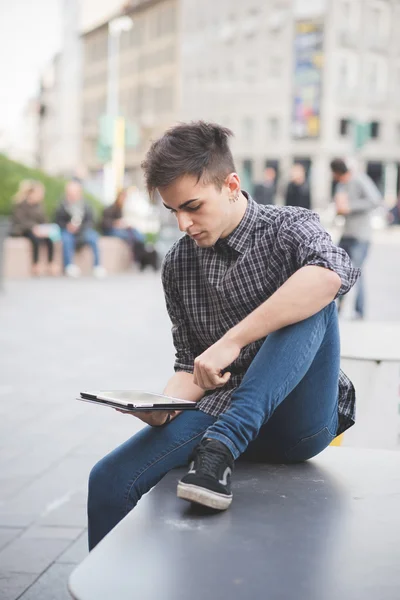 Joven hombre guapo con tableta en la ciudad — Foto de Stock