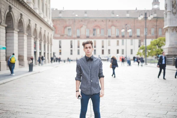 Joven guapo alternativa oscuro modelo hombre en la ciudad escuchar a m — Foto de Stock