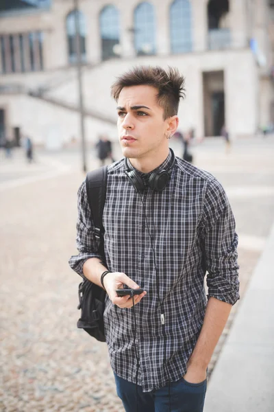 Joven hombre guapo con teléfono inteligente y auriculares —  Fotos de Stock