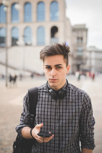 Όμορφος νεαρός με το smartphone και ακουστικά — Φωτογραφία Αρχείου