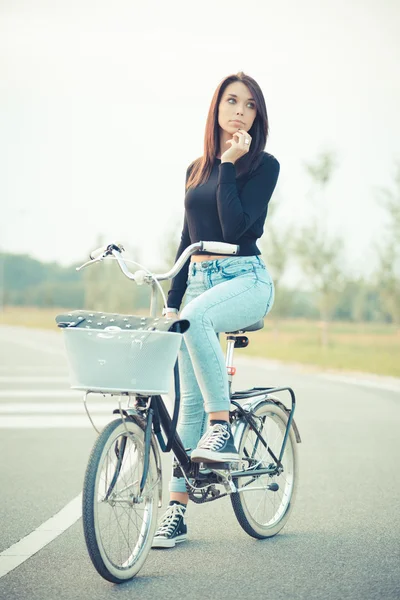 Молодая красивая женщина с велосипедом — стоковое фото