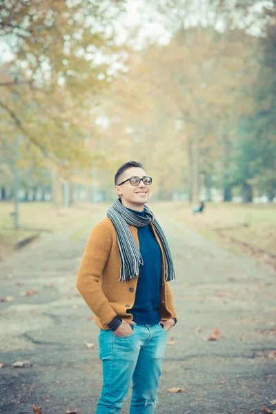 Giovane uomo caucasico bello nel parco autunnale — Foto Stock