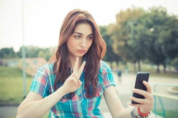 Hermosa joven hipster mujer usando teléfono inteligente — Foto de Stock