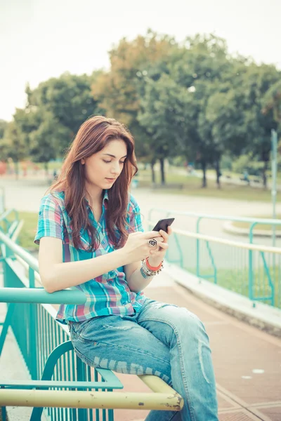 Hermosa joven hipster mujer usando teléfono inteligente — Foto de Stock