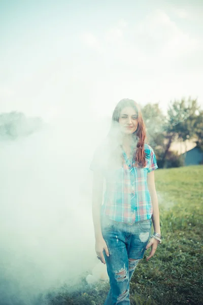 Beautiful young hipster woman smoke fog in the park — Stock Photo, Image