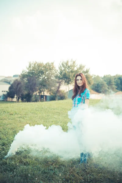 Beautiful young hipster woman smoke fog in the park — Stock Photo, Image