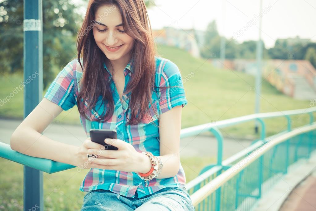 beautiful young hipster woman using smartphone