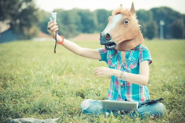 Mulher máscara de cavalo usando a tecnologia — Fotografia de Stock