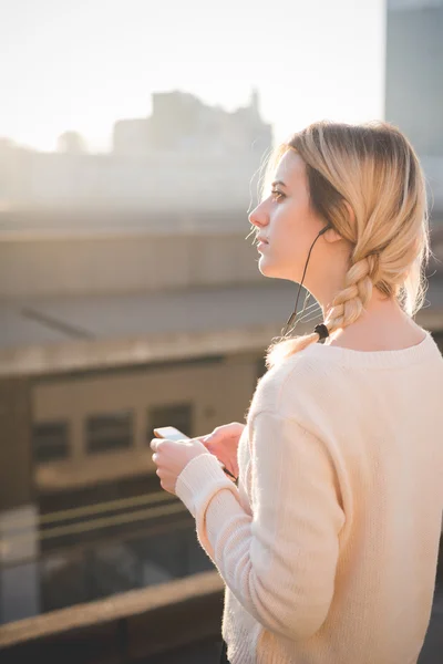 Blonde vrouw luisteren muziek buiten — Stockfoto