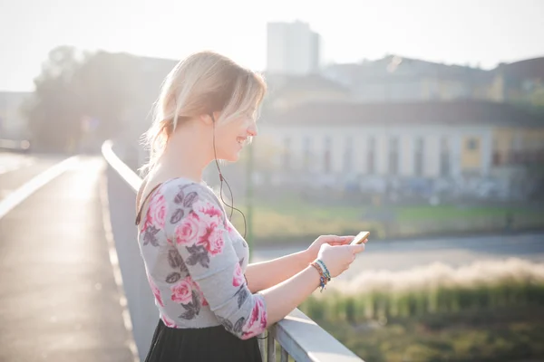 Mujer rubia escuchando música al aire libre — Foto de Stock